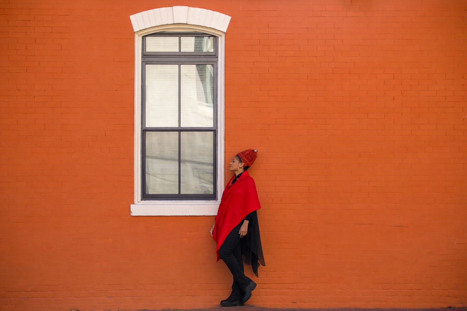 Traciana adossée à un mur de briques orange